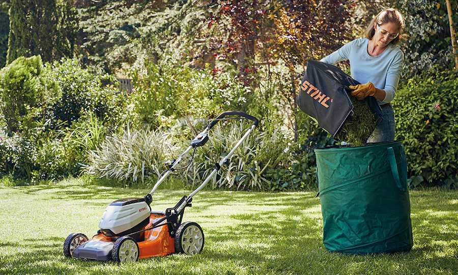 Woman emptying the bag from a STIHL RMA460 lawn mower