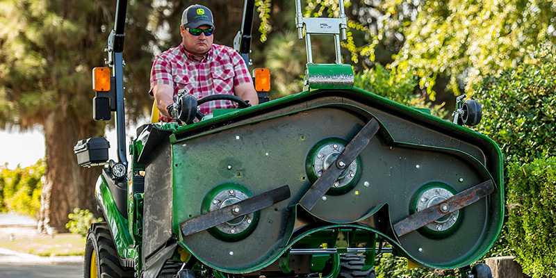 Tractor carrying a mower deck with the John Deere Load-N-Go attachment