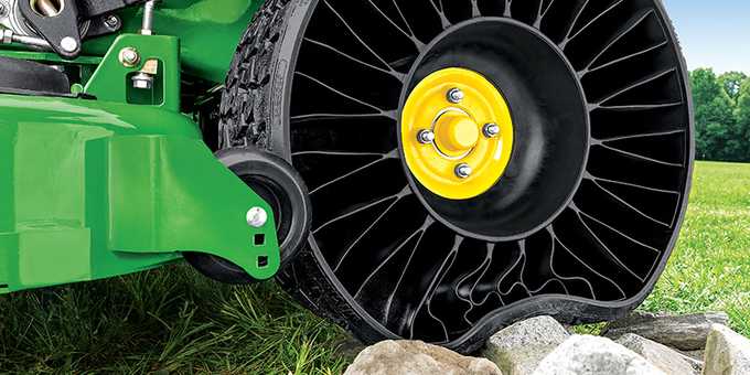 John Deere zero-turn mower with Michelin X Tweel Turf Airless Radial Tires driving over rocks